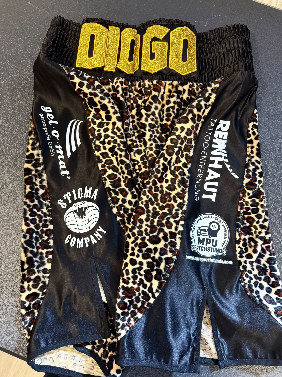 Diogos schwarz-goldene Boxhose mit Leopardenmuster und dem Logo der MPU-Sprechstunde unten rechts
