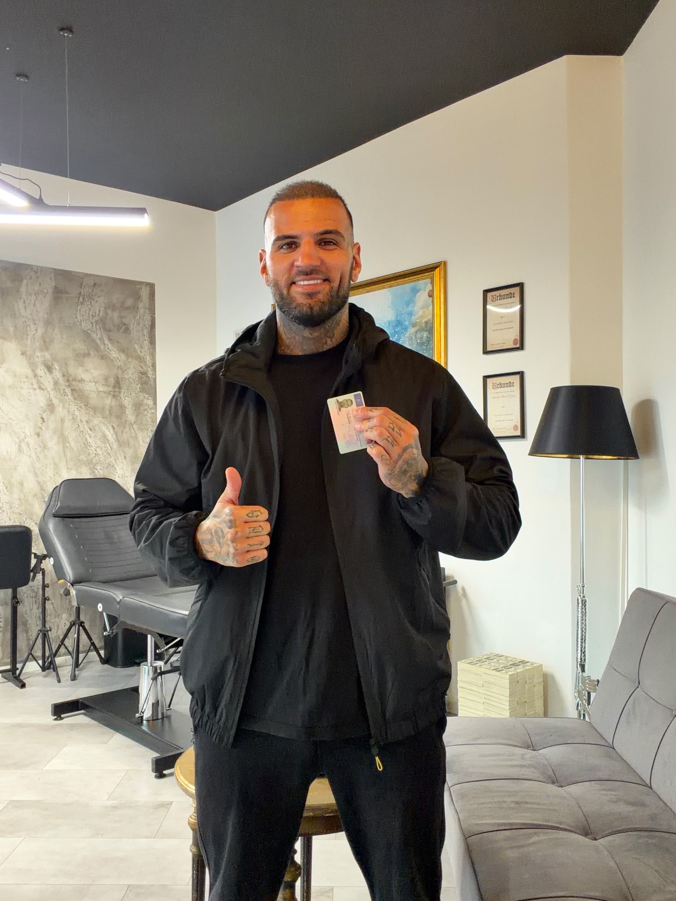 Diogo Sangre lächelt, hält eine Karte in der Hand und zeigt den Daumen nach oben